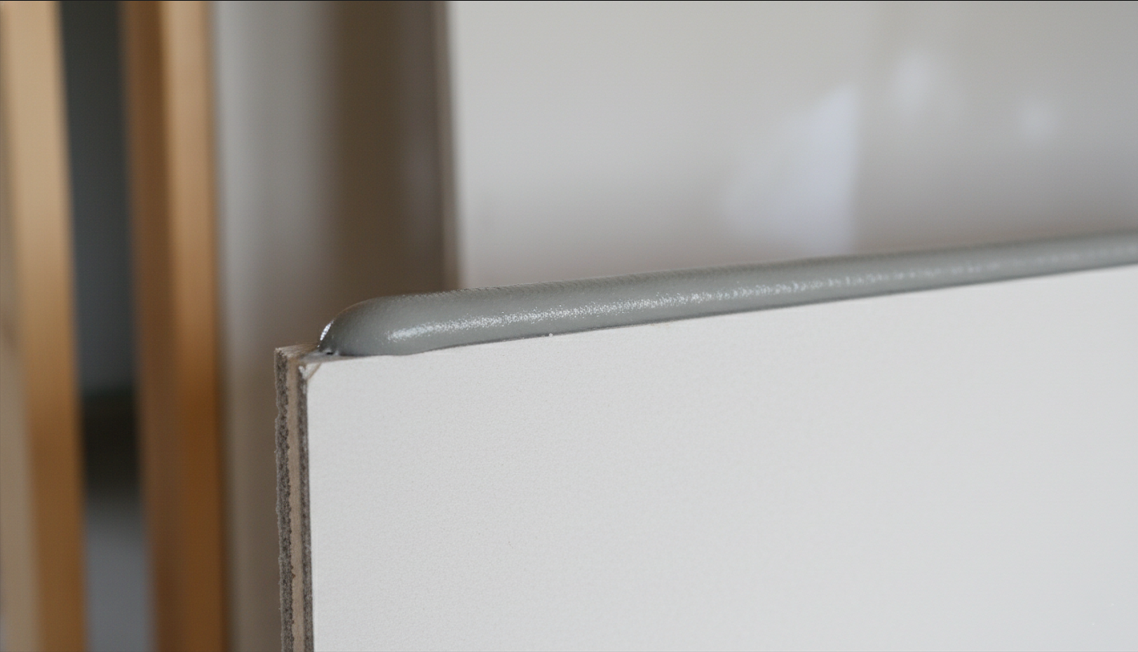 Acoustical sealant bead applied along the top edge of a drywall panel perimeter joint